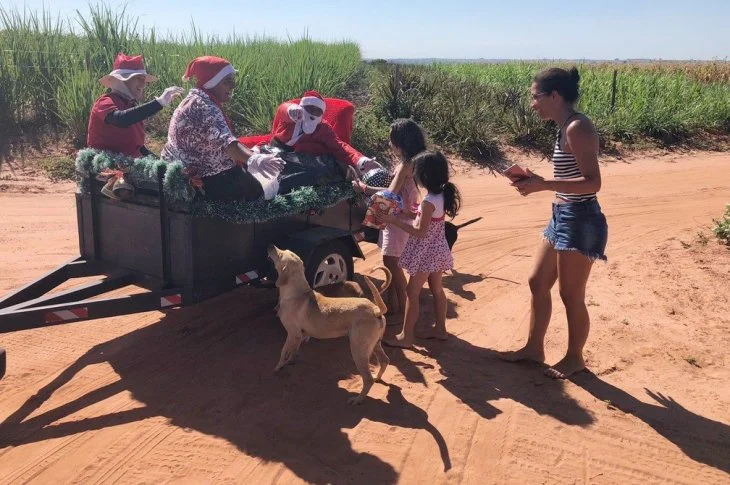 Sob sol de 35ºC, Papai Noel adapta 'trenó' a traseira de carro e distribui mais de 200 presentes a crianças em assentamento rural